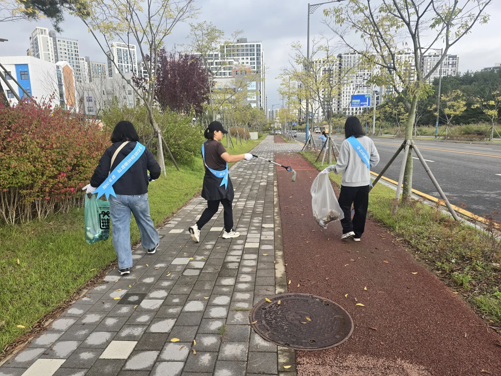 학부모들이 통학로를 걸으며 쓰레기를 줍고 있다. (사진=무안희망초 학부모회)